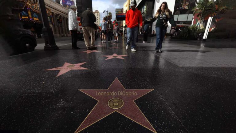 Estrellas del Paseo de la Fama de Hollywood en la acera con turistas caminando en Los Ángeles, California