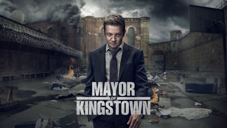 Póster de “Mayor of Kingstown” con el protagonista Mike McLusky (Jeremy Renner) en primer plano con una expresión intensa frente al paisaje urbano y penitenciario de Kingstown, con el título destacado.